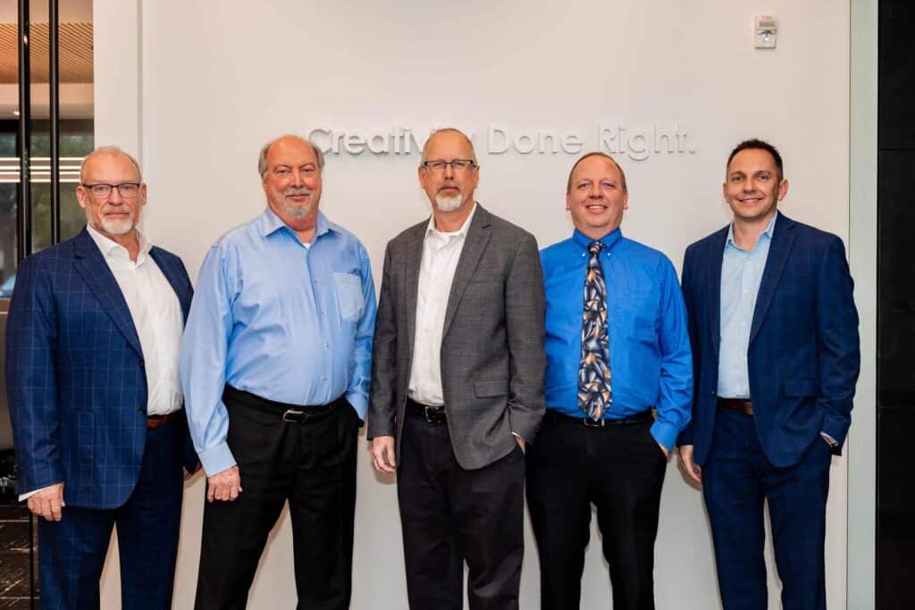 Five men in suits standing together, posed photo.