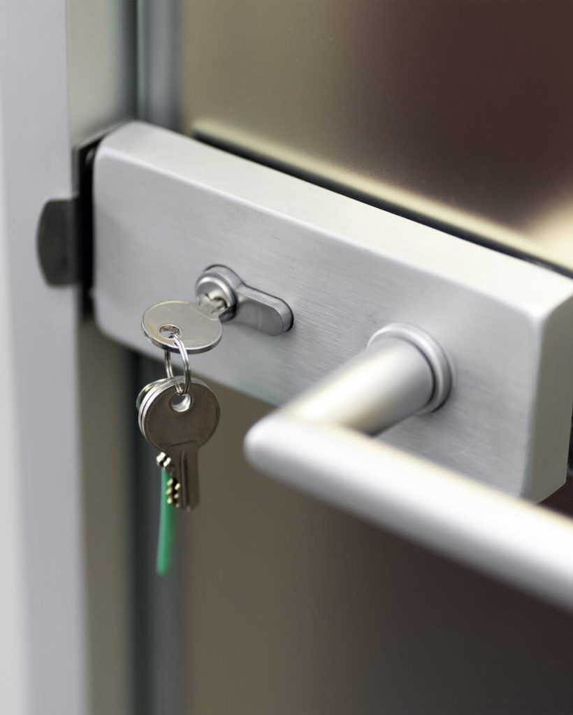 Modern door, key in the core of the lock, secure lock, security concept, closed door, closeup.