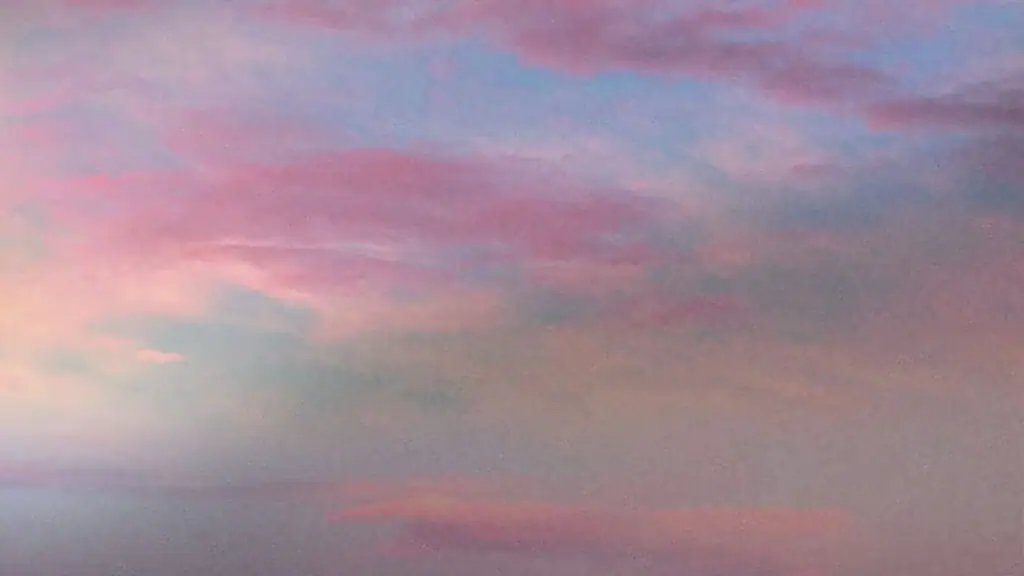 Beautiful sunset sky with pink and purple clouds over a calm horizon.