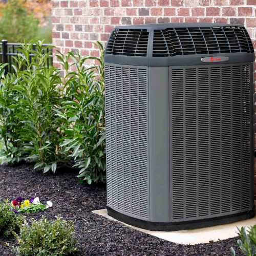 TRANE Air Conditioner installed on the side of a brick style house