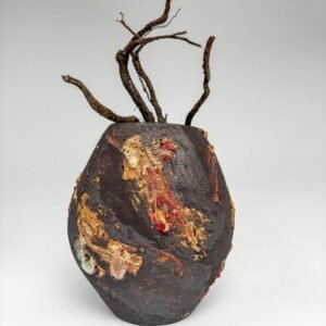 organic black ceramic sculptural vase with molten red and ochre glaze, placed on white background.