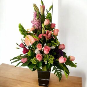 Ramo de flores elegantes con rosas, lirios y callas en tonos rosas y verdes, estilo moderno y sofisticado para ocasiones especiales.