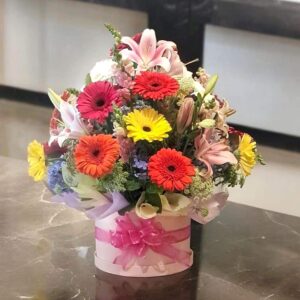 Ramos de flores con gerberas, lirios y rosa. Arreglo floral en caja decorada con lazo rosa, ideal para cumpleaños y eventos especiales, flores a domicilio en Nezahualcóyotl.
