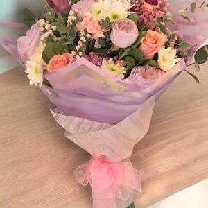 Ramo de flores con rosas, peonías y margaritas en estilo elegante con presentación en papel celofán rosa para obsequios especiales en Nezahualcóyotl.