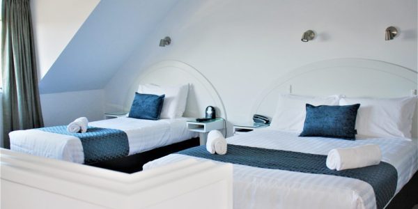 Modern hotel room with twin beds and contemporary decor, perfect for relaxing stays in New Zealand.