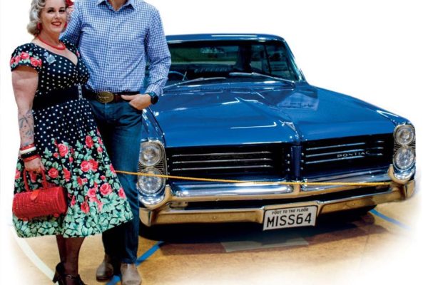 Classic American muscle car with vintage style and retro fashion enthusiasts at Americarna event in New Zealand.