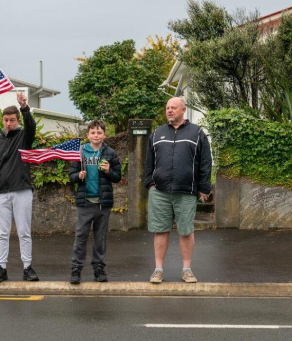 Patriotic Kiwi family celebrating America-themed event with American flags in New Zealand.