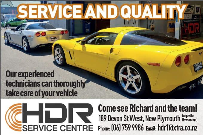 Yellow sports car and white sedan at car service centre in New Plymouth, New Zealand.