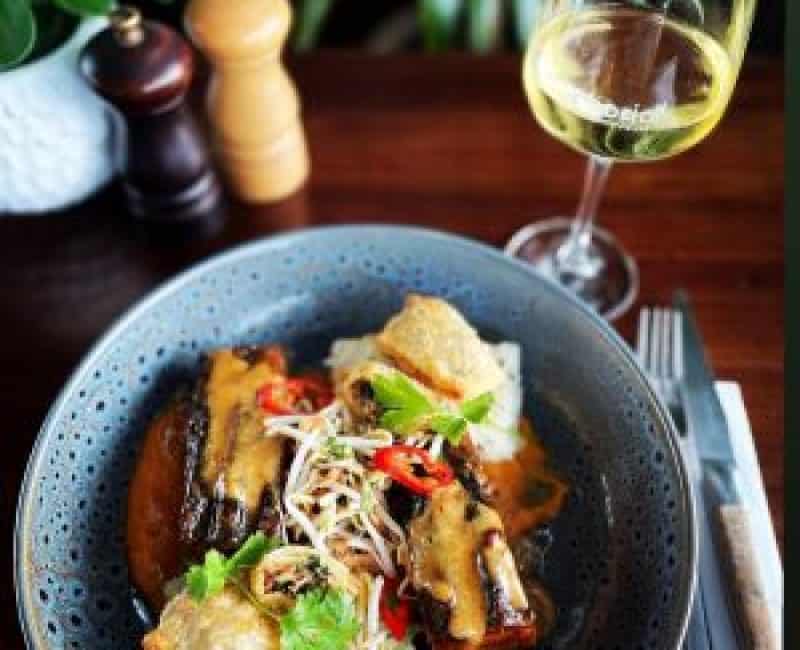 Delicious fish and seafood meal served with a glass of white wine, perfect for a dining experience.