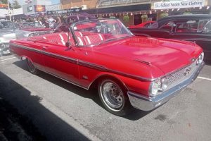 Vintage red convertible car on display at Americarna event in New Zealand, showcasing classic automotive beauty.