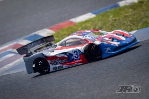 High-speed race car with American flag-themed livery on track during Americarna festival in New Zealand.