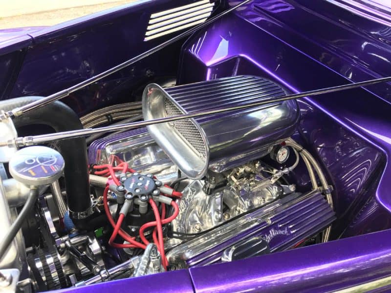 High-performance vintage hot rod engine showcasing chrome parts and custom purple paint.