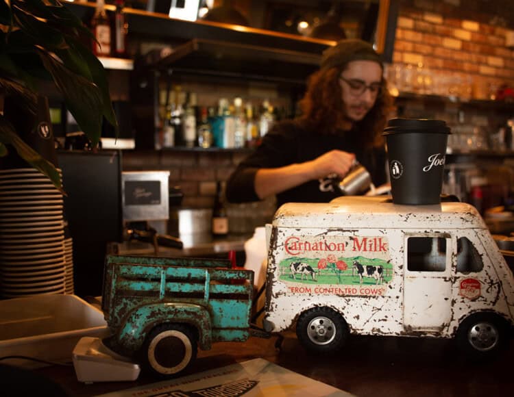 Rustic toy dairy truck decor at Americarna, New Zealand motor vehicle event; vintage style with cows and milk.