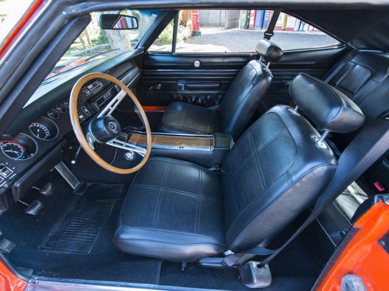 Interior of a vintage American classic car with leather seats and wooden steering wheel.