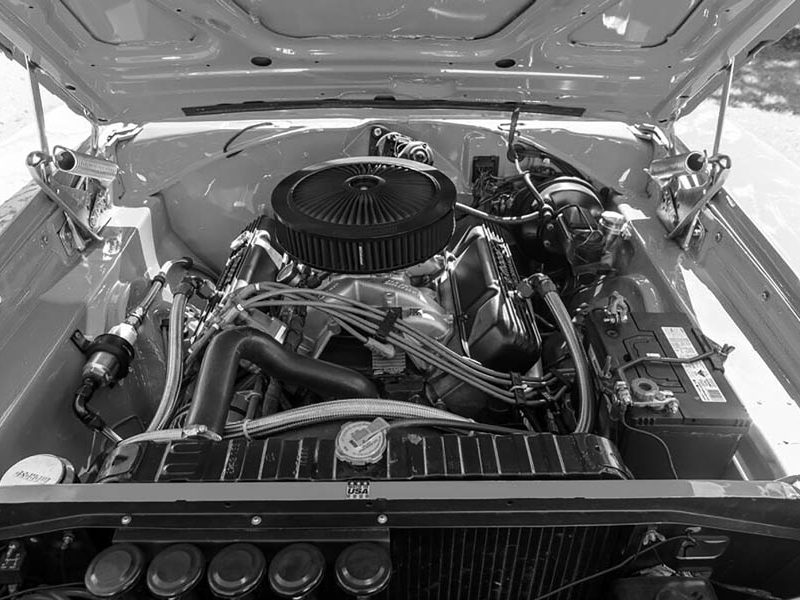 Detailed view of vintage American muscle car engine bay.