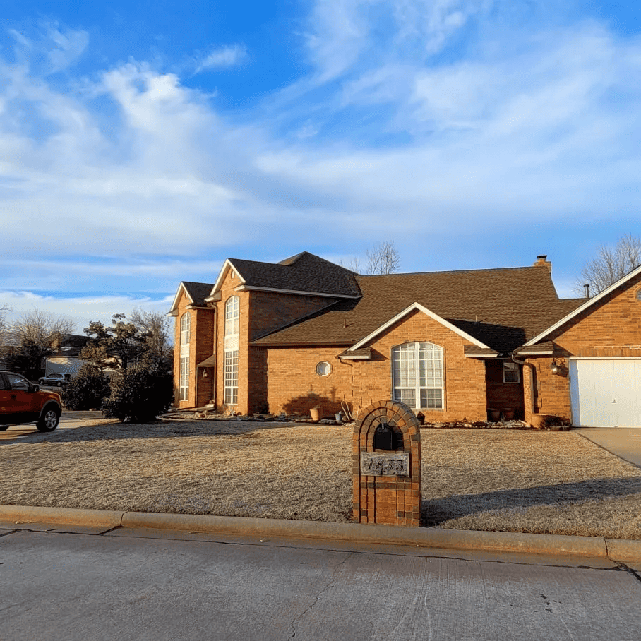 Beautiful brick house with new roofing in a suburban neighborhood.