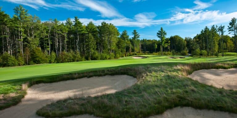 Lush golf course with sandy bunkers.