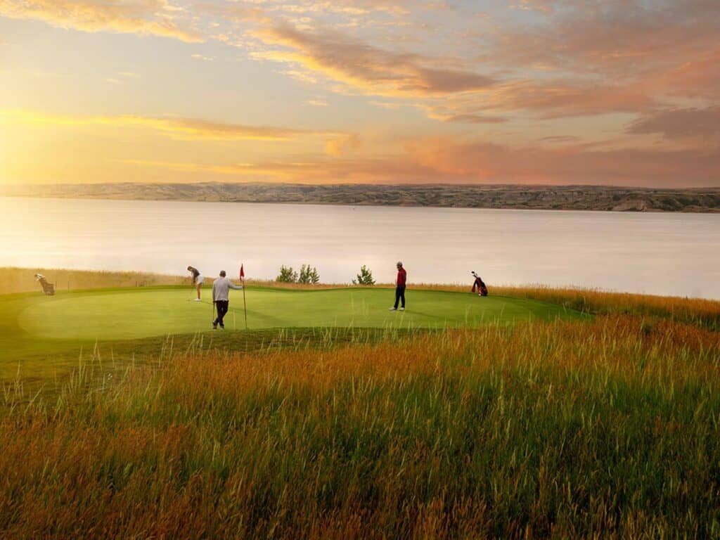 Golfers on green at sunset