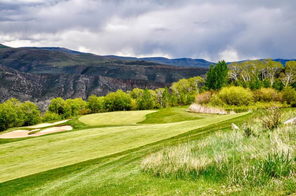 Scenic golf course with lush green fairways and mountain backdrop.