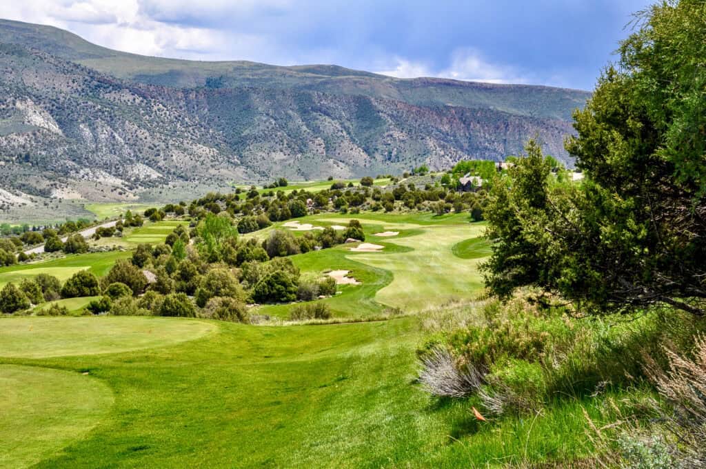 Scenic golf course with lush green fairways and mountain backdrop.