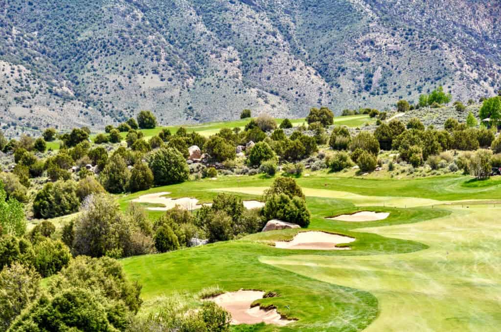Scenic golf course with lush green fairways and mountain backdrop.