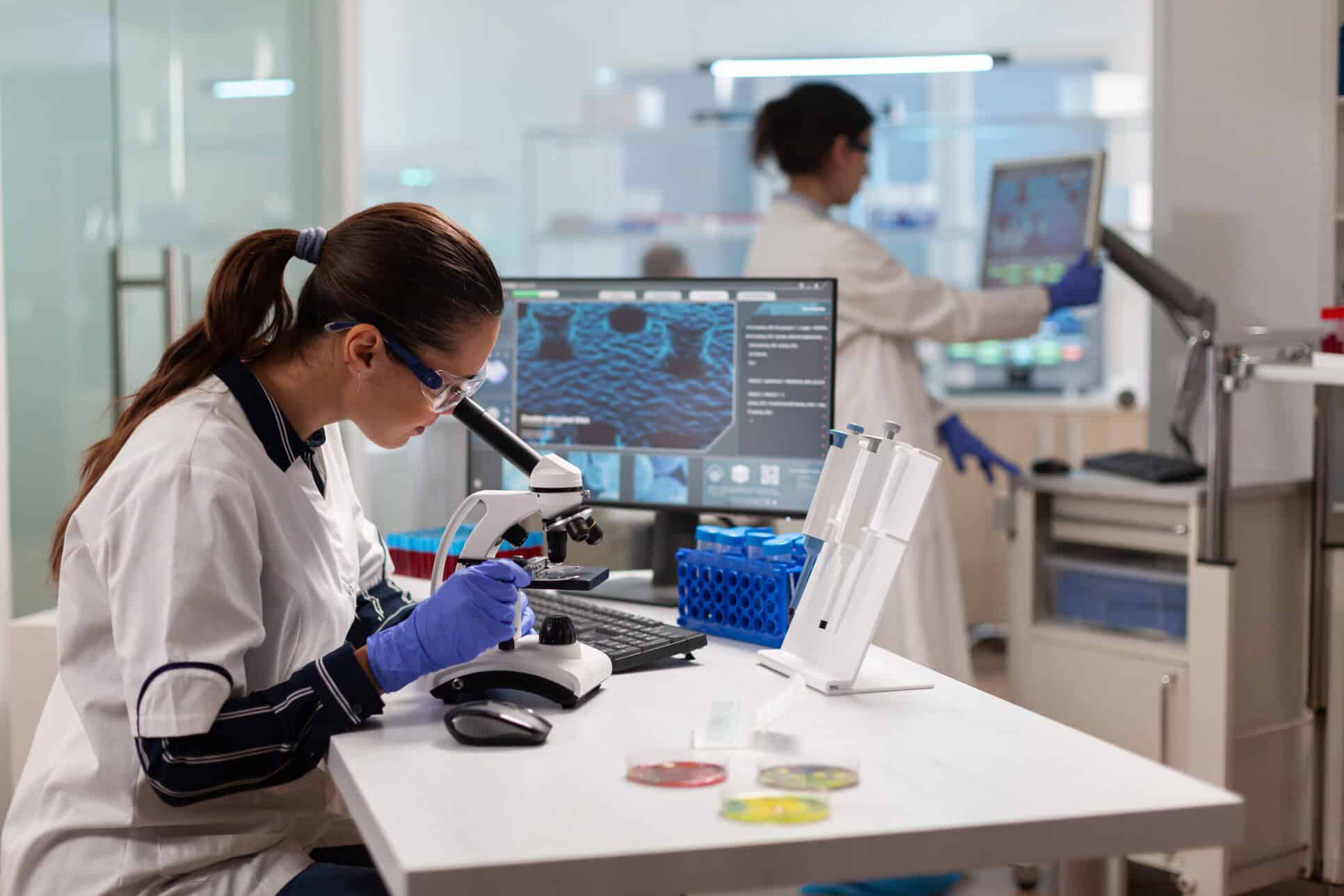 Scientists conducting laboratory research at Amino Pharm, using microscopes and advanced equipment to develop health and wellness supplements.