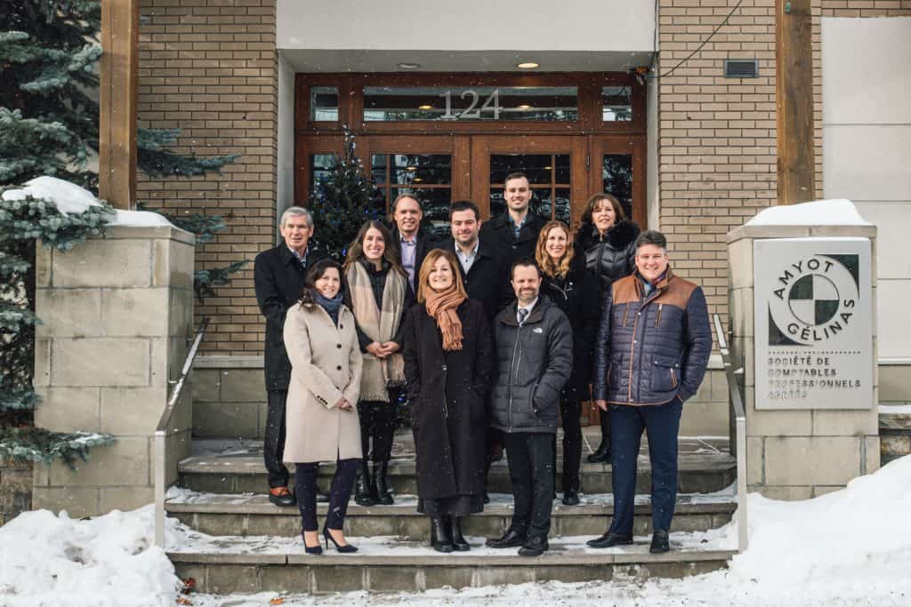 Groupe de professionnels devant le siège de la société Amyot Gelinas en hiver.