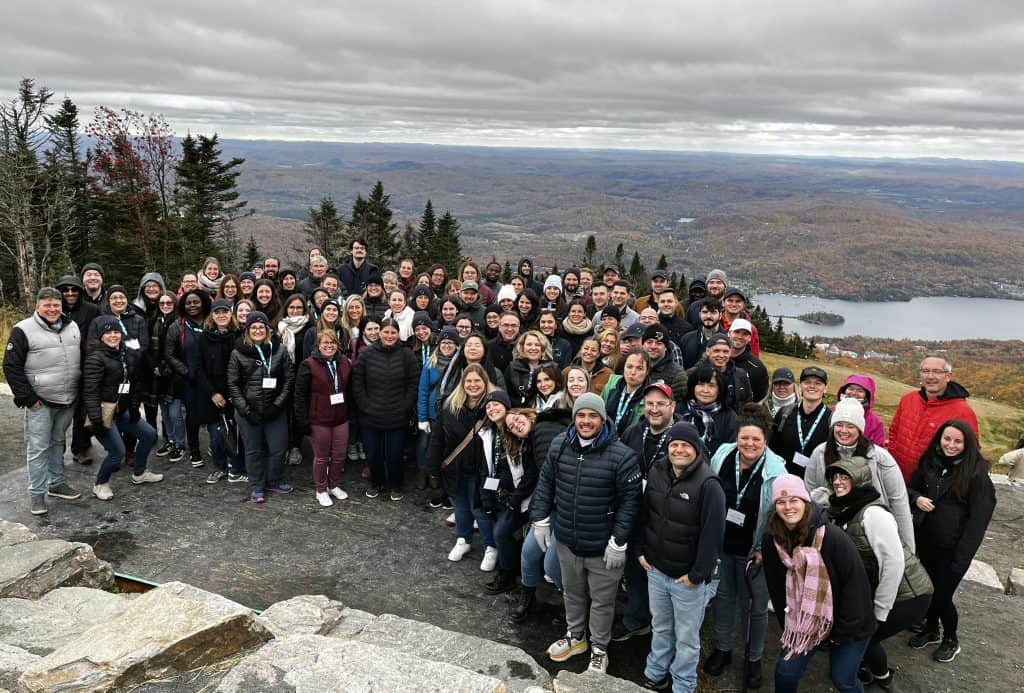 Groupe de personnes lors d'une excursion en pleine nature avec vue panoramique sur un lac et des montagnes, en automne, vêtus de vêtements chauds.