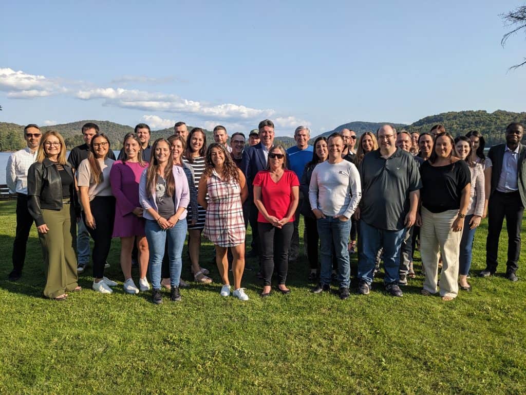 A group of people on an outdoor outing with mountain scenery in the background.