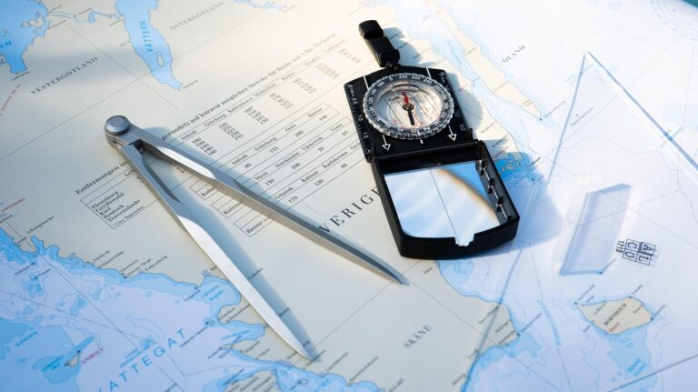Boussole sur une carte maritime, outils de navigation pour l'exploration en milieu marin, planification de voyage maritime, précision en navigation océanique, équipement nautique.