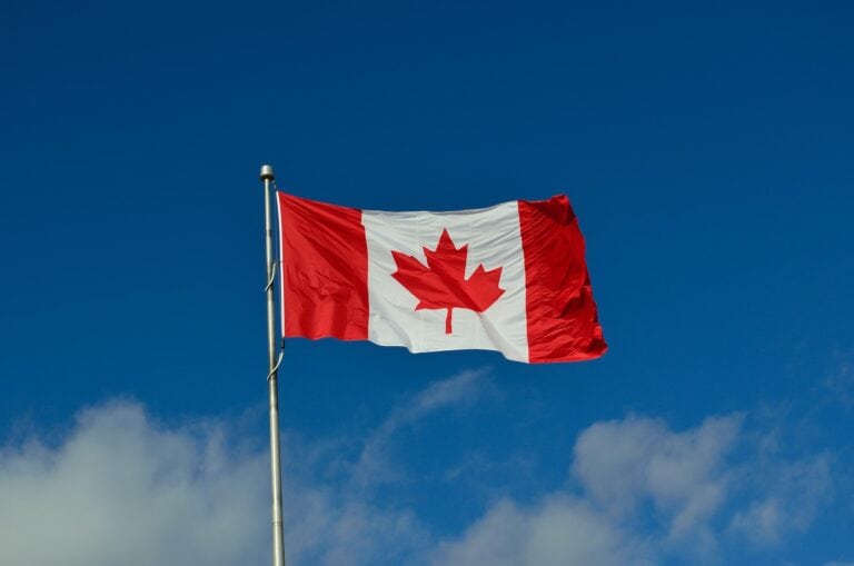 Une image de le drapeau canadien flottant dans le ciel bleu, symbolisant les annonces fiscales du budget fédéral 2025.