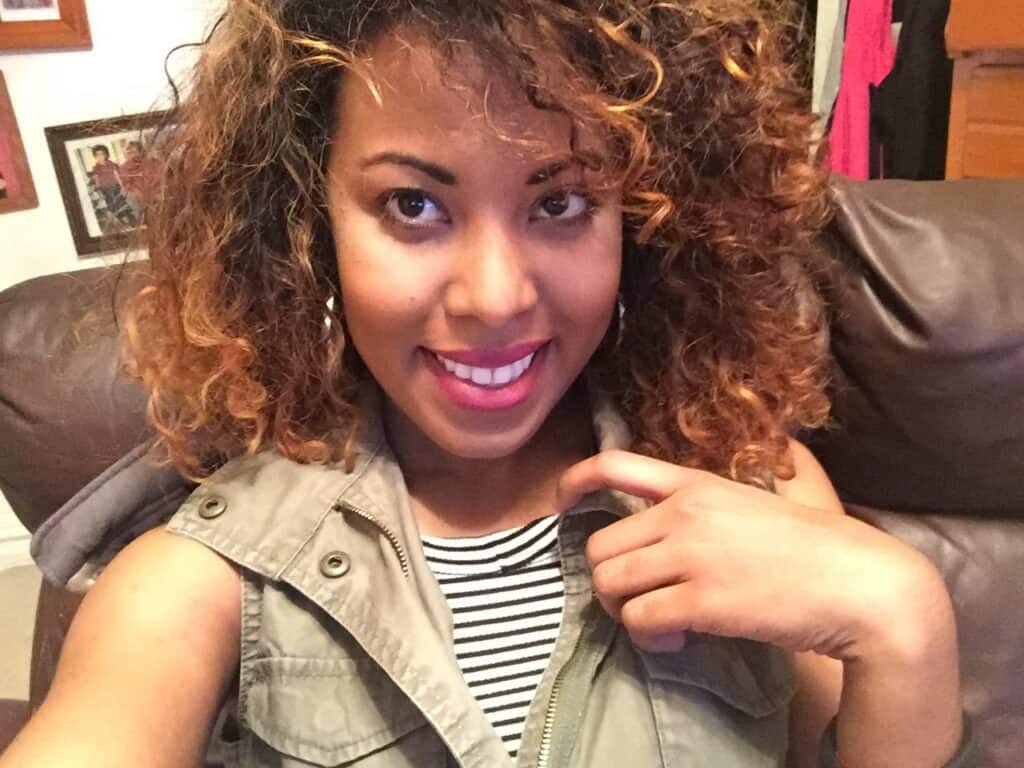 Close-up selfie showing curly hair with uneven texture and visible dye damage