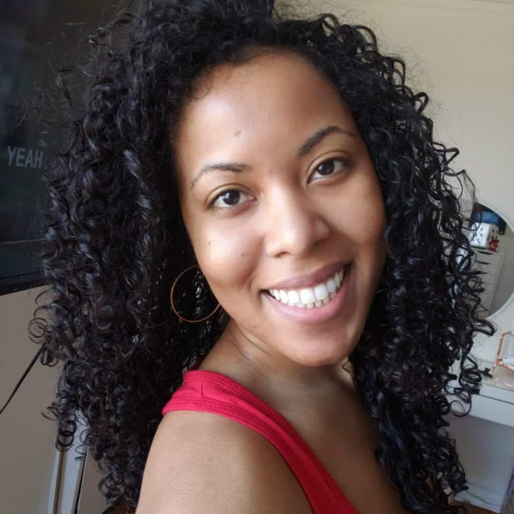 Ana smiling with natural curls, wearing a red tank top — Curly Mama Chronicles founder
