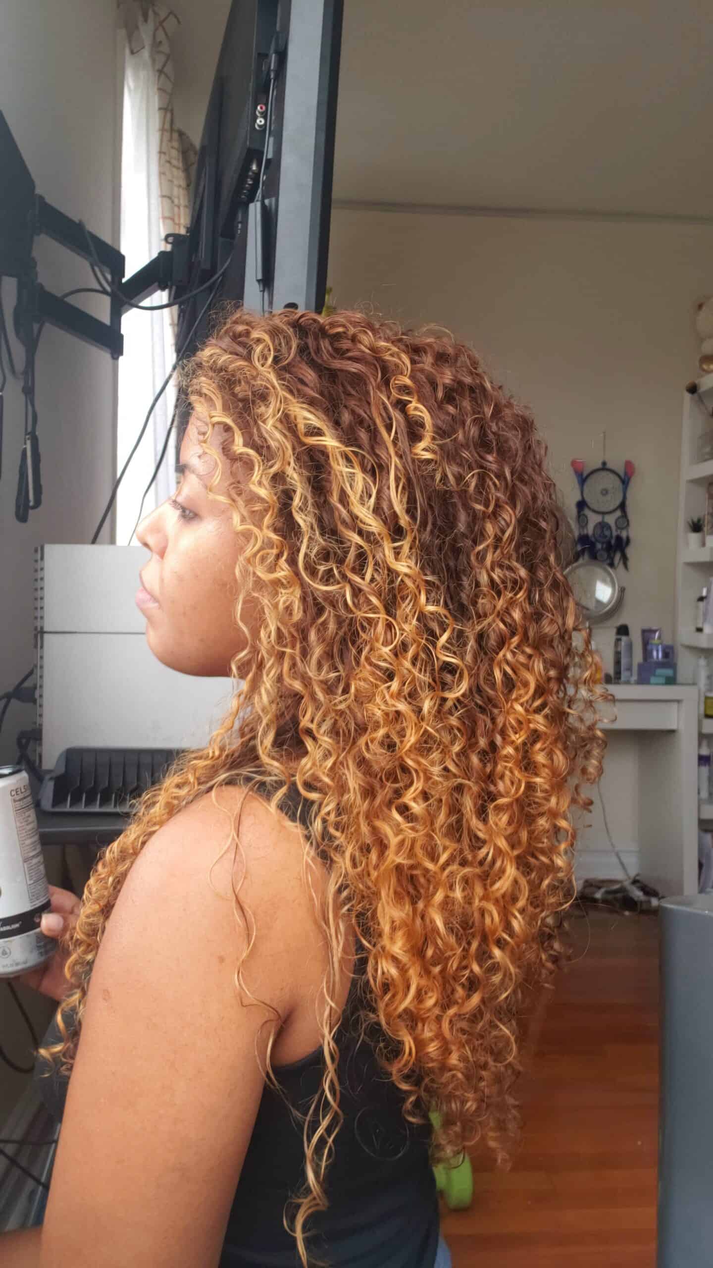 Ana with highlighted curly hair in profile view, embracing curly hair journey
