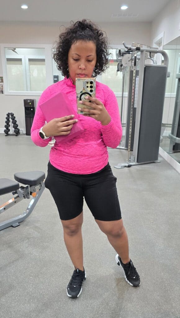Postpartum mom at the gym taking a mirror selfie – fitness progress and empowerment