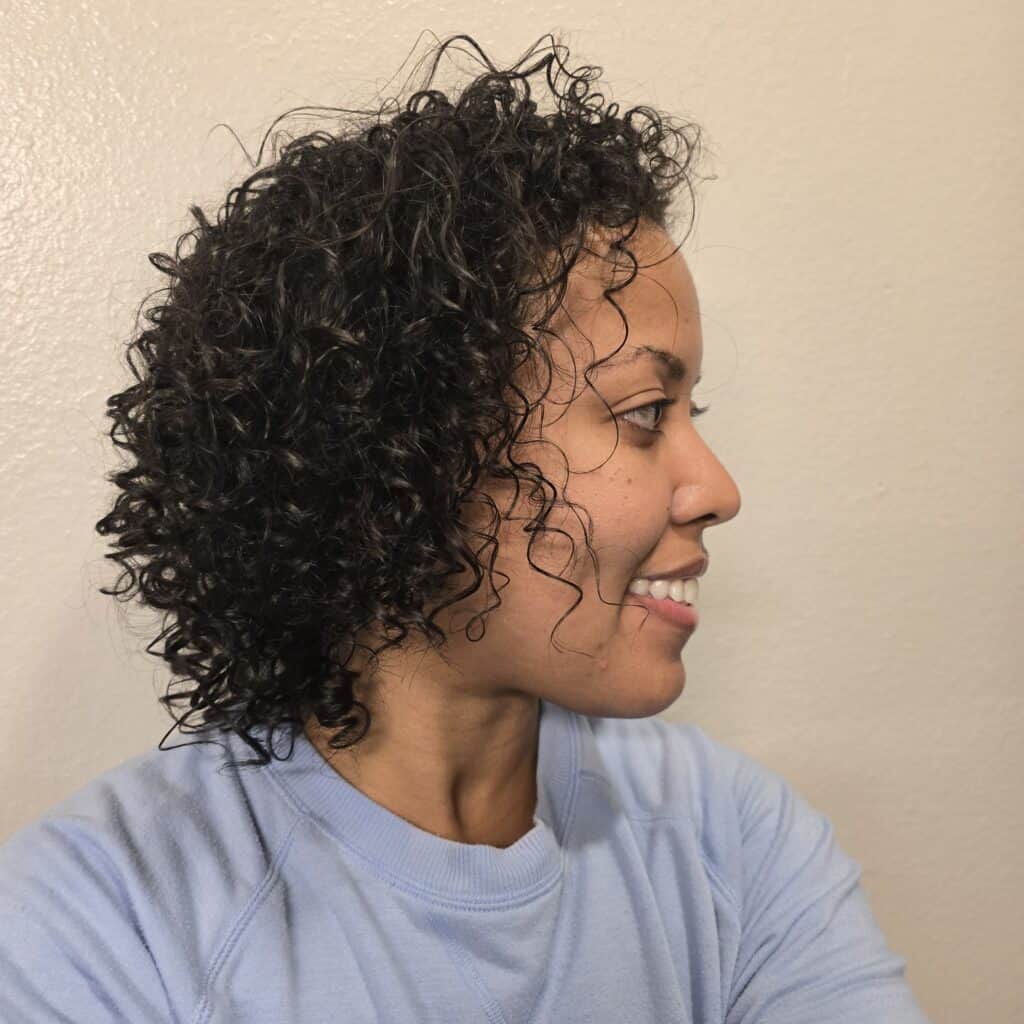 Back view of shoulder-length curls with visible shine and moisture.