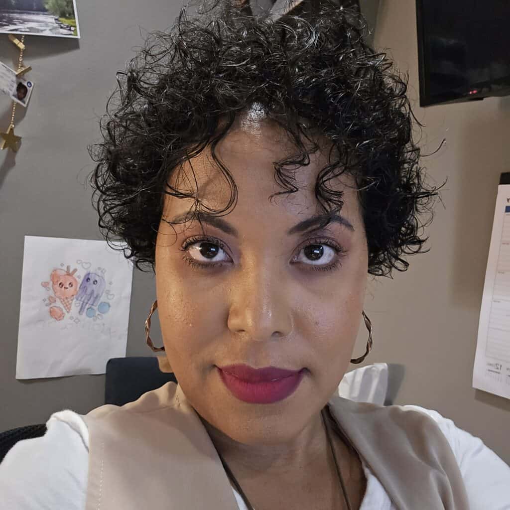 Woman with defined curls beginning to show noticeable hair growth and curl pattern definition.