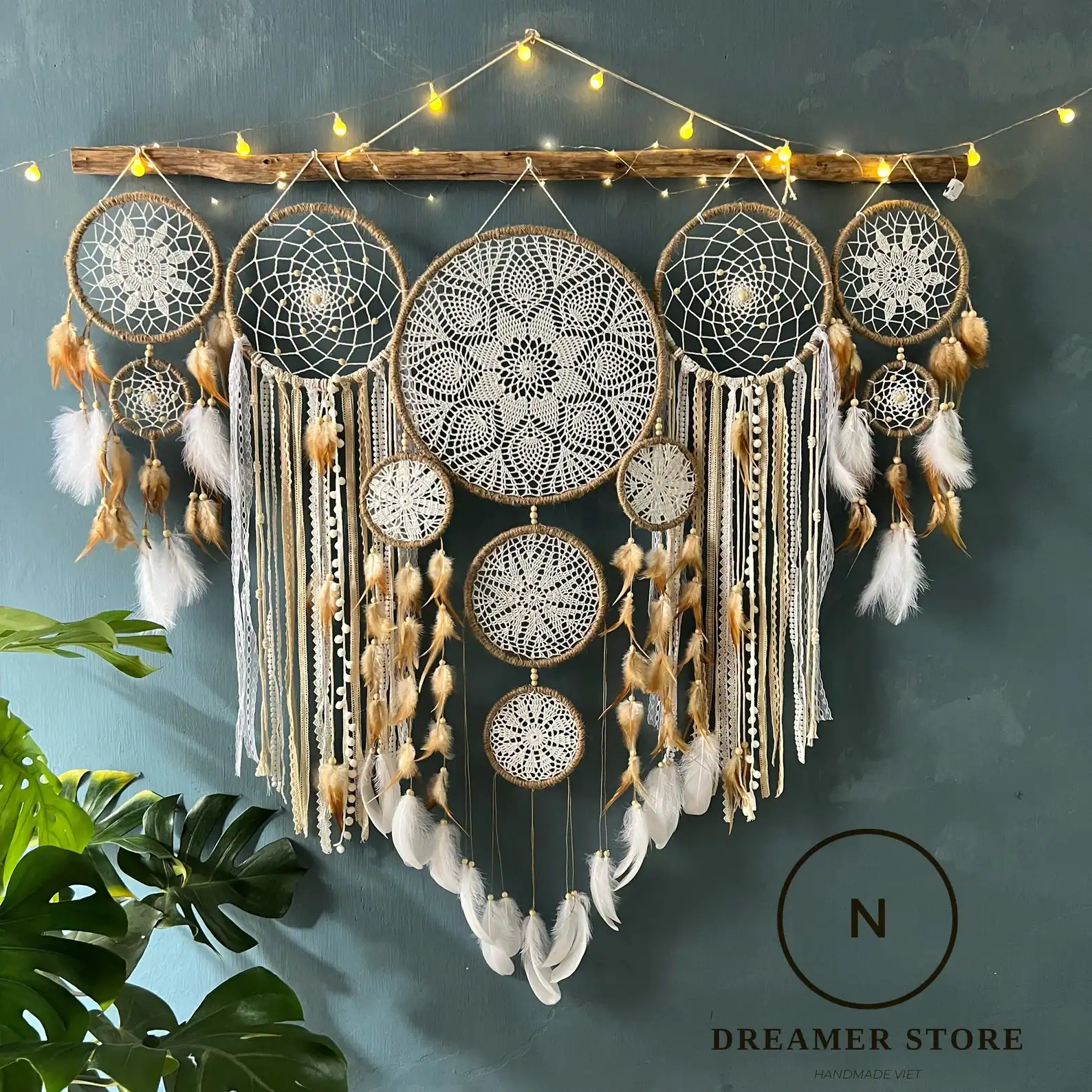 Handmade fabric dreamcatcher wall hanging with fringe, styled on a white wall. Soft and textural, ideal for toddler-friendly home decor.