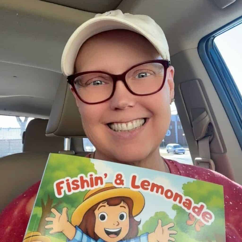 Dionna Cameron holding a copy of her book and smiling at the camera.