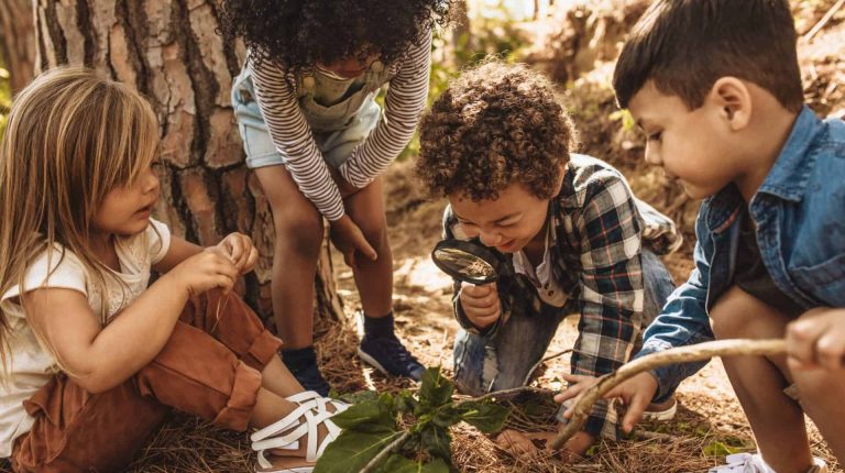 Kids in forest with a magnifying glass