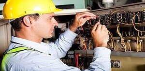 male electrician testing industrial machine
