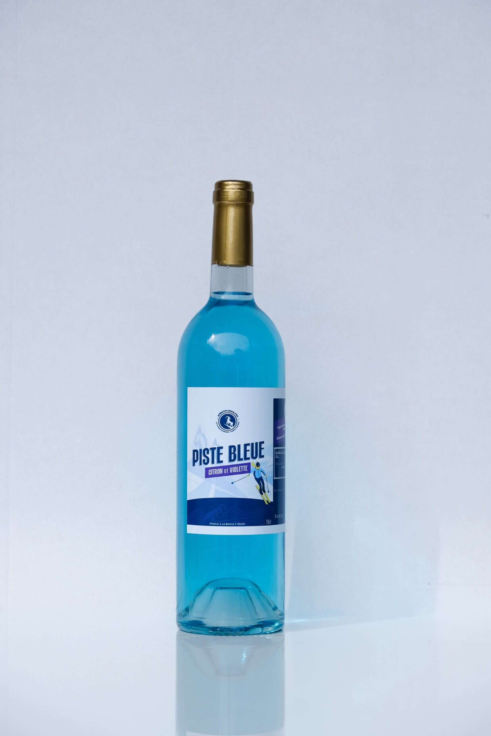 Bouteille de liqueur bleue "Piste Bleue" avec étiquette violette, idéale pour apéritifs insolites.