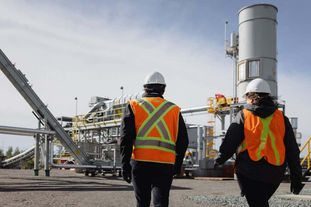 Two people walking through the Arbios Chuntoh Ghuna facility