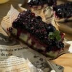 A delectable portion of irresistible blueberry cheesecake bars, featuring creamy cheesecake layers with a luscious blueberry swirl, ready to be savored