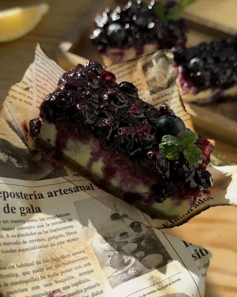 A delectable portion of irresistible blueberry cheesecake bars, featuring creamy cheesecake layers with a luscious blueberry swirl, ready to be savored