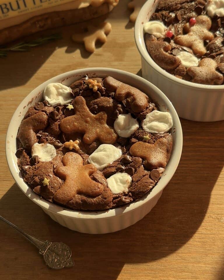 Fluffy and tender Christmas brownies with a rich chocolate base, melted marshmallows, chocolate drops, and topped with festive gingerbread cookies and star sprinkles. Perfect for the holiday season