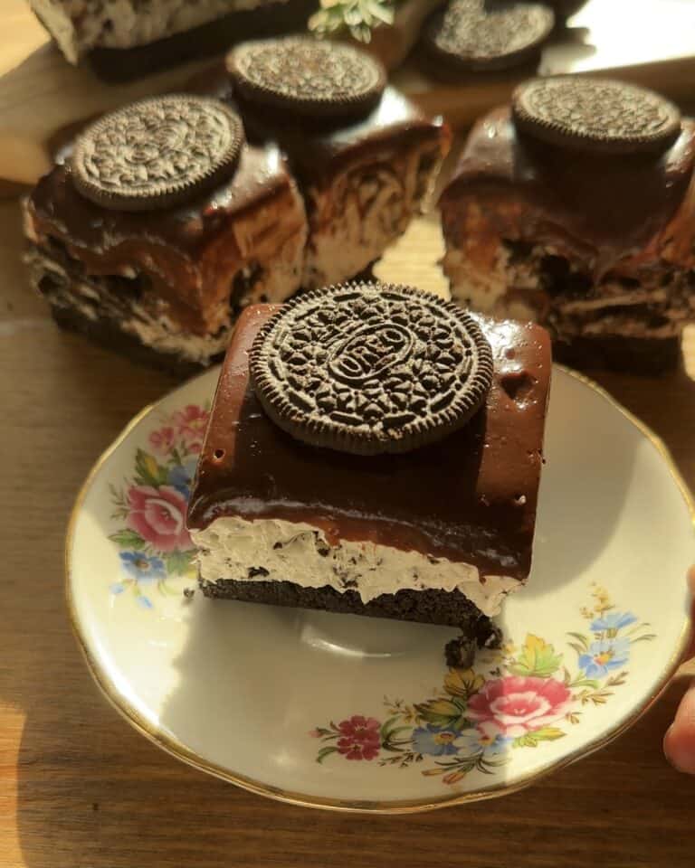Delicious No-Bake Oreo Cheesecake Bars, ready to eat with a smooth, creamy filling and a crunchy Oreo crust, topped with ganache and Oreos for extra flavor