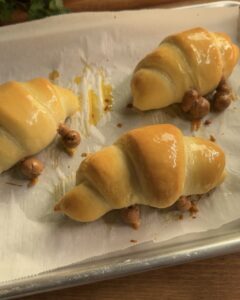 Freshly baked Jellycat croissant, golden brown and ready to eat, with a flaky, buttery texture