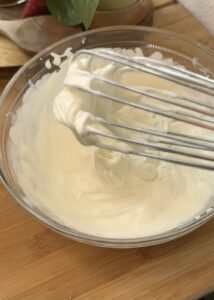 A bowl of freshly whipped cream, ideal for making a creamy no-bake pistachio cheesecake filling.
