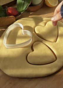 Cutting rolled-out dough with a heart-shaped cutter for Nutella heart donuts, perfect for Valentine’s Day desserts.